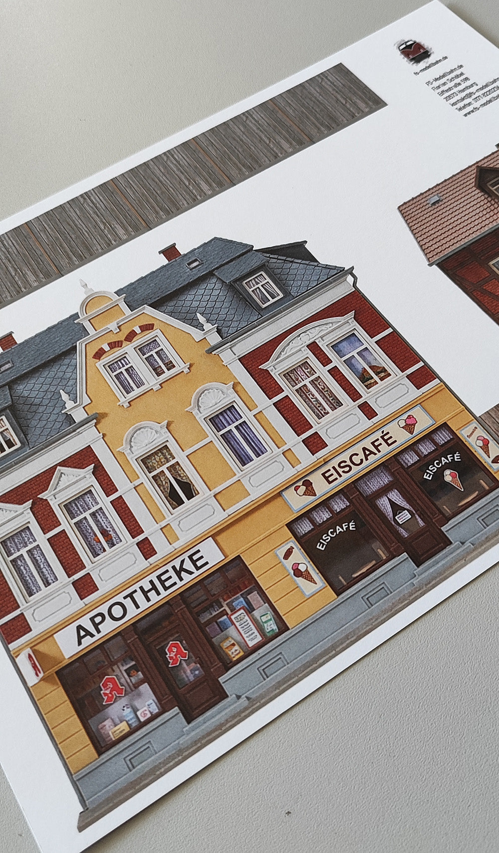 Model railway background pharmacy and ice cream parlor in magnificent Wilhelminian style building and grocery store and wooden fence H0 1:87