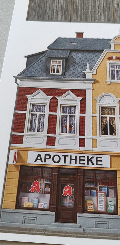 Model railway backdrop Pharmacy and Ice Cream Parlor in magnificent Wilhelminian-era building and grocery store and wooden fence H0 1:87